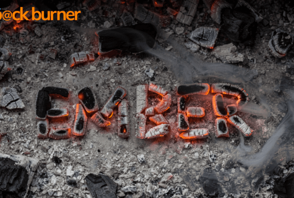 a photograph of ashes and embers, the embers form the word "EMBER"